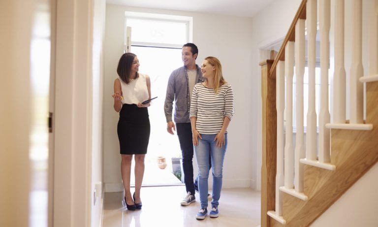 Realtor Showing Young Couple Around Property For Sale