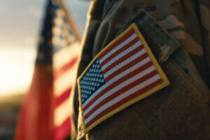 Military servicemember standing in front of the American flag