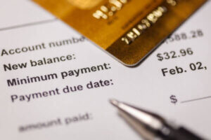 Minimum payment statement with pen and credit card.